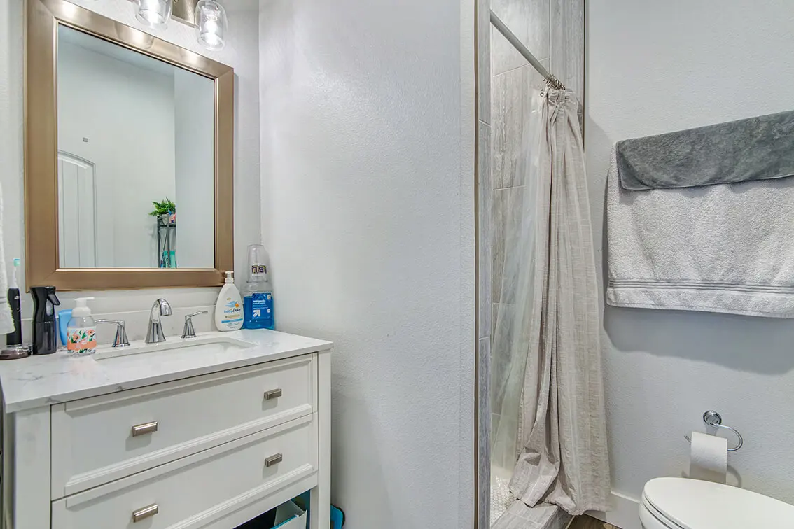 404 Industrial Park bathroom with a white vanity, framed mirror and shower (6)