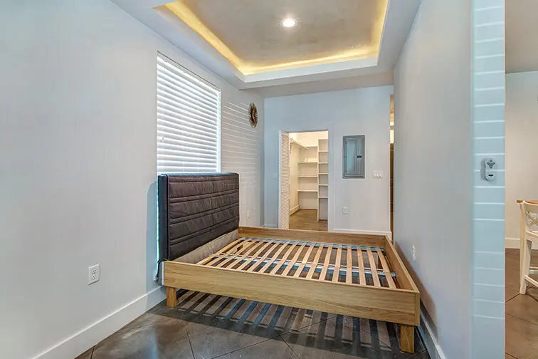 Bedroom at 404 Industrial Park with a lit tray ceiling and a walk-in closet beyond (9)