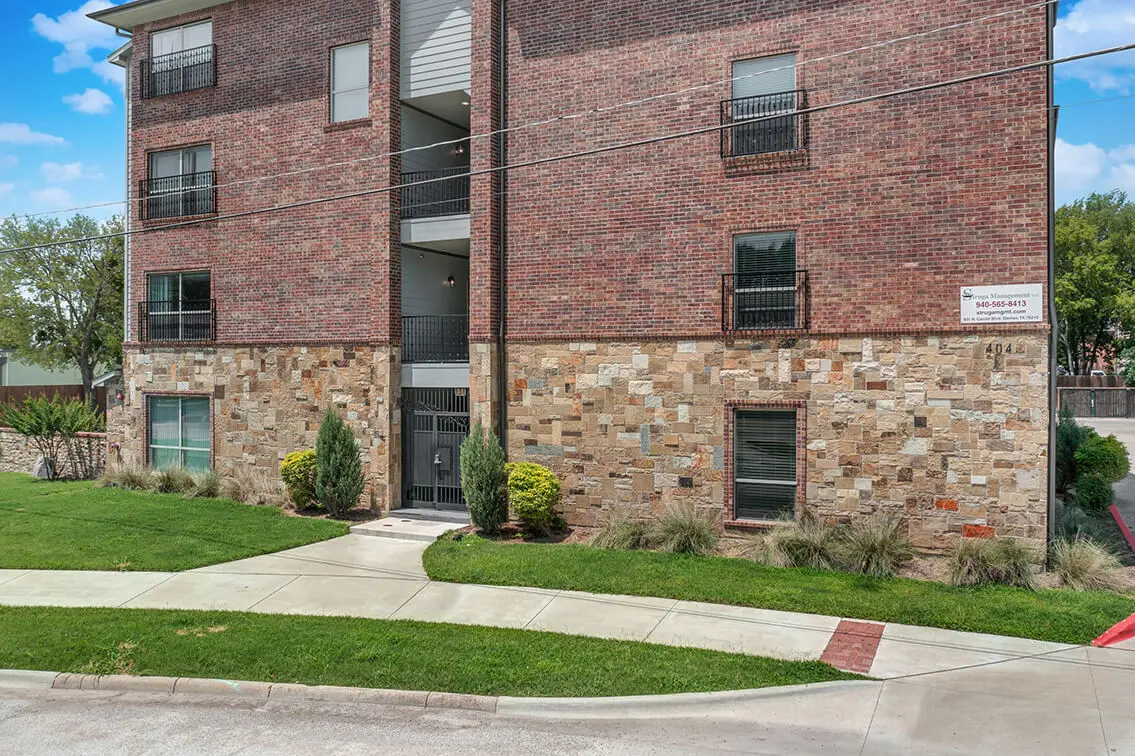 Side of 404 Industrial Park with a gated stairwell entry and a landscaped lawn (3)