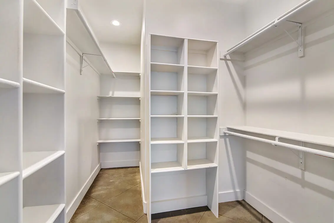 Walk-in closet with built-in shelves and hanging rods at 404 Industrial Park (12)