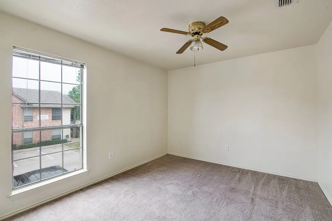 Carpeted Cole Place bedroom with a ceiling fan and a large window (8)