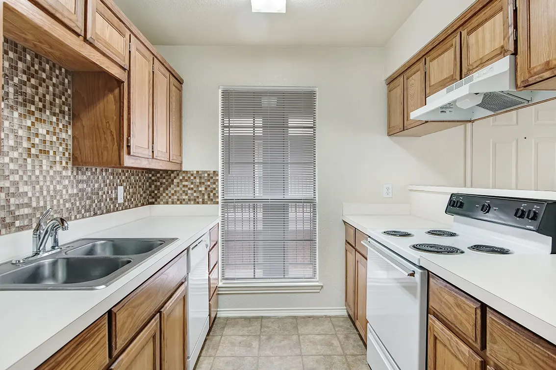 Cole Place kitchen with wood cabinets, a mosaic tile backsplash, double sink and electric range (7)
