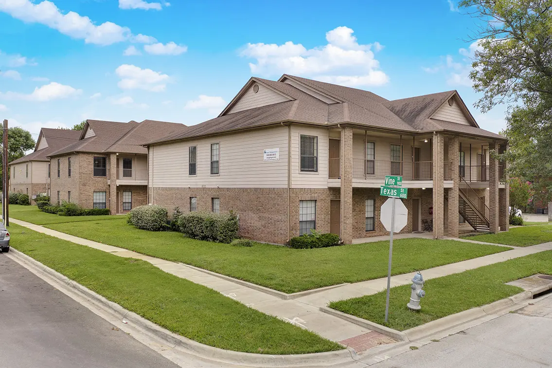 Lone Star two story brick and siding building on a street corner with a green lawn (4)