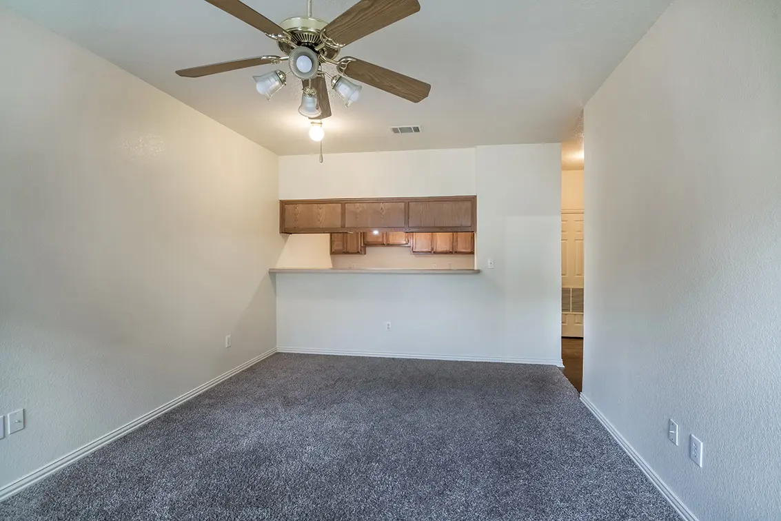 Carpeted Lone Star living room with a ceiling fan, facing the kitchen pass-through (6)