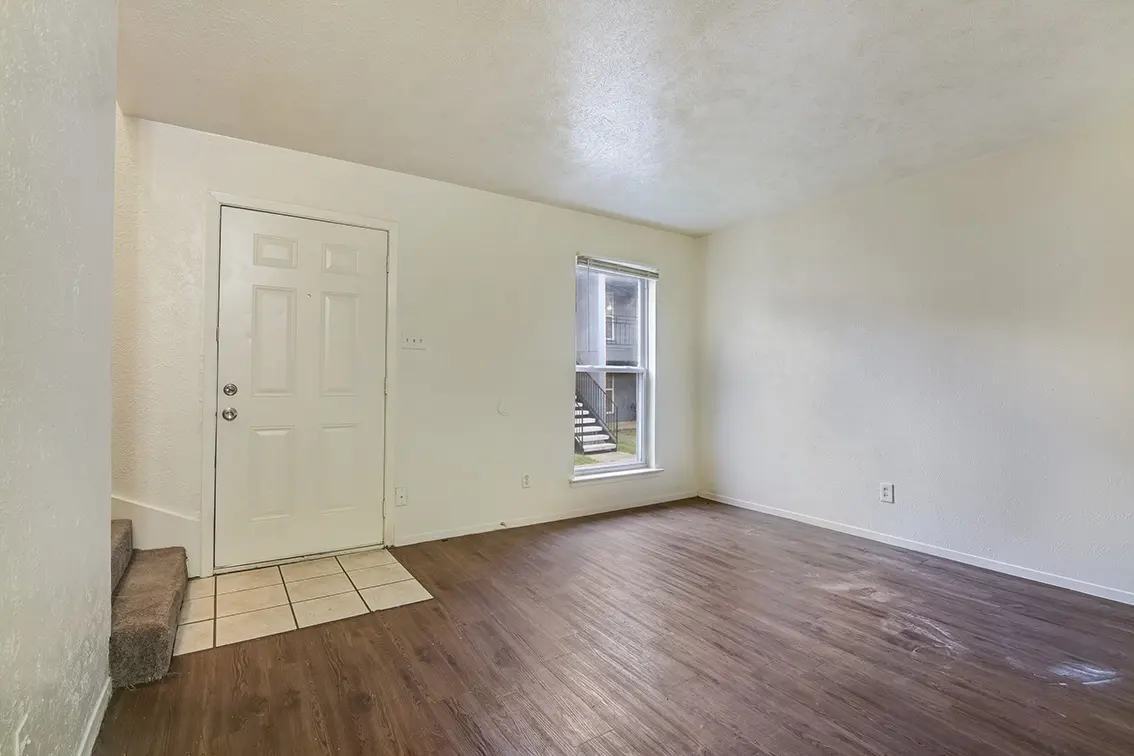 The Clusters living room with the front door, a tiled entry and stairs at left (7)